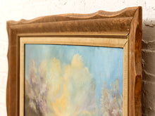 Load image into Gallery viewer, Close-up of a framed painting showing a soft-focus landscape with blue sky, yellow light, and muted trees, set in a rustic brown wooden frame against a white brick wall.