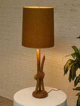 Load image into Gallery viewer, Vintage table lamp with sculptural curved wood base and tall brown woven-texture shade illuminated with a warm glow
