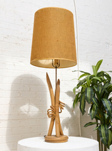 Load image into Gallery viewer, Vintage table lamp with sculptural curved wood base and tall brown woven-texture shade illuminated with a warm glow