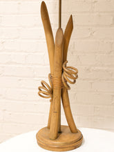 Load image into Gallery viewer, A vintage wooden hair stand with four curved wooden sticks wrapped in tan cord, mounted on a round base, set against a white brick wall.