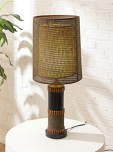 Load image into Gallery viewer, Vintage table lamp with tall brown woven shade, black cylindrical base, warm wood accents, and wrapped textured detailing