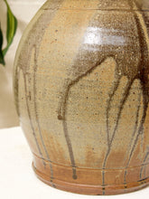 Load image into Gallery viewer, Close-up of a ceramic vase with a rounded body, featuring a speckled beige and brown glaze with dark brown drip patterns running down the surface.