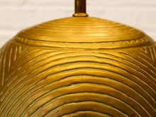 Load image into Gallery viewer, Close-up of a metallic gold dome-shaped object with concentric wavy ridges and a small vertical rod at the top, set against a light neutral background.