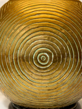Load image into Gallery viewer, Close-up of a round metallic object with concentric circular ridges and a reflective gold finish, showing a small central spiral detail.