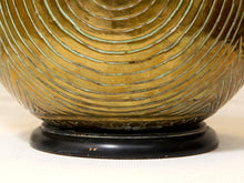 Load image into Gallery viewer, Close-up of a decorative ceramic vase or planter with a textured concentric wavy pattern in olive green and gold tones, sitting on a round black base against a light neutral background.