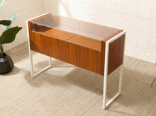 Load image into Gallery viewer, Danish modern wood jewelry display case with clear glass top, multiple shallow drawers, and squared metal frame and legs
