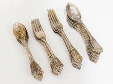 Load image into Gallery viewer, Antique F.B. Rogers Silver Co. silver-plated flatware set with ornate floral scrollwork handles, including forks and spoons with aged patina