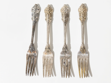 Load image into Gallery viewer, Four ornate silver forks with decorative handles, arranged vertically side-by-side against a plain white background.