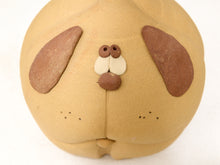 Load image into Gallery viewer, A close-up of a handmade clay dog face sculpture on a plain white background.