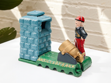 Load image into Gallery viewer, Vintage cast iron artillery bank with standing soldier, cannon, green textured fort, and colorful painted details