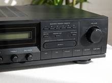 Load image into Gallery viewer, Vintage black Optimus AM/FM stereo receiver with rectangular digital tuner display, large volume knob, front control buttons, and vented top panel