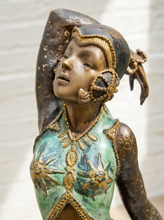Load image into Gallery viewer, A close-up of a decorative figurine or sculpture of a woman in profile, with a patinated turquoise-green torso, gold-toned detailing, and a dark bronze head and arm. The background is a softly blurred light neutral wall.