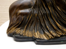 Load image into Gallery viewer, Close-up detail of a bronze sculpture showing draped fabric folds with a textured, metallic finish on a white surface.