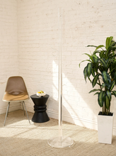 Load image into Gallery viewer, Vintage freestanding clear Lucite coat rack featuring a tall transparent cylindrical column, curved transparent hooks at different heights, and a round clear base.