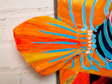 Load image into Gallery viewer, Contemporary tropical fish painting by Jean Bradley featuring a vibrant orange, turquoise, and coral fish with intricate swirling patterns, prominent eye, and fins extending beyond the dark navy canvas.