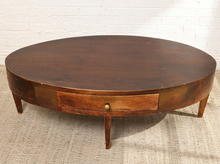 Load image into Gallery viewer, Image 5 of 16: Vintage elongated oval wooden coffee table featuring a dark brown wood finish, gently curved apron, single front storage drawer with a round metal knob, slender tapered legs, and visible surface wear.