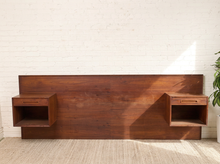 Load image into Gallery viewer, Image 2 of 22: Vintage Danish modern teak headboard featuring a long rectangular wood panel with rich reddish-brown grain and two adjustable open-box nightstands positioned near either end, compatible with queen or king beds.