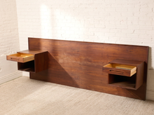 Load image into Gallery viewer, Image 6 of 22: Vintage Danish modern teak headboard featuring a long rectangular wood panel with rich reddish-brown grain and two adjustable open-box nightstands positioned near either end, compatible with queen or king beds.