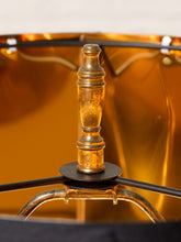 Load image into Gallery viewer, Image 9 of 19: Close-up of a vintage-style lamp shade featuring a polished brass central finial, black metal support arms, and a warm amber-gold interior.