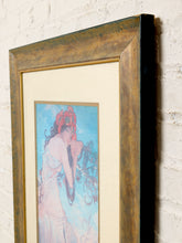 Load image into Gallery viewer, Image 6 of 8: A framed art print featuring an Art Nouveau style illustration of a woman in a pink dress against a light blue background, housed in a distressed brown wooden frame with a cream mat, leaning against a white brick wall.