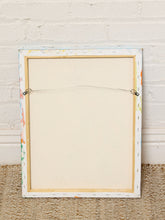 Load image into Gallery viewer, Image 8 of 8: The back view of a square framed canvas print, showing the off-white fabric surface, metal hanging clips, and a white brick wall background.