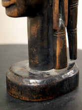 Load image into Gallery viewer, Image 13 of 13: Close-up detail of a carved wooden figurine showing a dark brown and black painted finish with natural wood grain on a dark surface.
