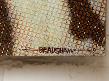 Load image into Gallery viewer, Image 8 of 9: Close-up of a textured snakeskin-patterned surface in beige, brown, and black, with the name 'BRADSHAW' written across the lower edge.