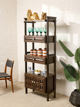 Load image into Gallery viewer, Image 2 of 25: Vintage dark wood étagère bookshelf featuring three open display shelves, two drawers with raised rectangular panel details, a lower double-door cabinet with geometric square panels, and round cream-colored knobs.