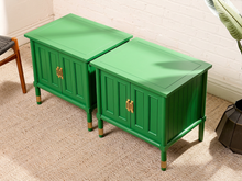 Load image into Gallery viewer, Image 3 of 21: Pair of vintage Kelly green cabinet nightstands featuring vibrant green painted finishes, vertical fluted side panels, two paneled cabinet doors each, brass-tone handles, square inset tops, and slender legs with brass-tone feet.