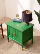 Load image into Gallery viewer, Image 6 of 21: A bright green side cabinet with gold handles, styled in a room corner with a purple lamp, a small clock, and books on top.