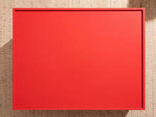 Load image into Gallery viewer, Image 11 of 21: A square red tray or shallow frame with a thin red border, photographed from above on a beige woven fabric background.