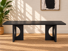Load image into Gallery viewer, Sylvia dining table in Charcoal with rectangular rounded-edge top and sculptural black fluted pedestal bases with circular cutouts.