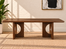 Load image into Gallery viewer, Sylvia dining table in Natural Brown Walnut with rectangular rounded-edge top and sculptural fluted pedestal bases with circular cutouts.