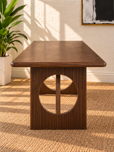 Load image into Gallery viewer, Sylvia dining table in Natural Brown Walnut with rectangular rounded-edge top and sculptural fluted pedestal bases with circular cutouts.