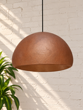 Load image into Gallery viewer, Tayla hanging lamp in terracotta with a wide dome-shaped textured fiber cement shade and black suspension cord.