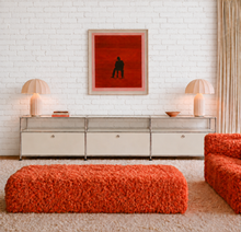 Load image into Gallery viewer, Modern three-drawer media console with chrome-toned frame, glass shelves, light neutral cabinet fronts, and open storage compartments.