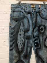 Load image into Gallery viewer, Cesar Platero hand-painted blue denim jeans with large black and gray abstract shapes, circles, lines, and expressive graphic artwork.