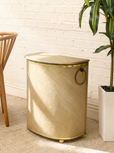 Load image into Gallery viewer, Vintage beige Atomic Age clothes hamper with rounded lid, brass-tone trim, textured patterned finish, and metal starburst accent