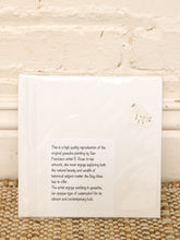 Load image into Gallery viewer, A square white art print or book cover wrapped in protective plastic, leaning against a light beige brick wall on a woven tan rug. The cover contains black descriptive text about San Francisco artist D.