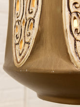 Load image into Gallery viewer, Close-up of a decorative ceramic vase or lantern with a warm brown body and raised cream-colored scrollwork panels outlined in dark brown.
