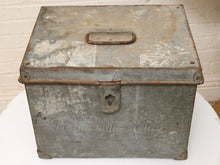 Load image into Gallery viewer, A vintage galvanized metal storage box with a hinged lid, rusted metal handle, and latch closure, displayed on a white surface against a white brick wall.