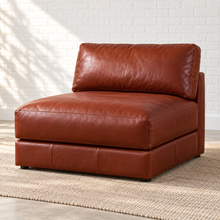 Load image into Gallery viewer, Image 2 of 5: Simulated three-quarter view of the Montara armless chair in Brighton Hero brown leather, with a deep seat and low base in Sunbeam’s white brick setting.