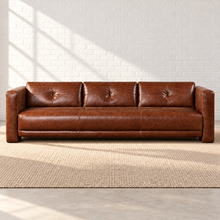 Load image into Gallery viewer, Image 6 of 6: Simulated front view of the 96-inch Sullivan Estate Sofa in Crystal Ranch brown leather, with three tufted back panels and a wide tailored seat in the Sunbeam setting.