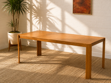Load image into Gallery viewer, Rectangular oak dining table with warm natural wood grain, minimalist design and slender architectural corner legs.
