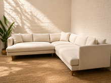 Load image into Gallery viewer, Modern cream tweed L-shaped sectional sofa with chaise, plush back cushions, accent pillows and tapered wood legs.

