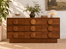 Load image into Gallery viewer, Nine-drawer Moonlight wood dresser with warm wood grain, low rectangular silhouette, and oversized round wooden drawer pulls
