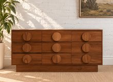 Load image into Gallery viewer, Nine-drawer Moonlight wood dresser with warm wood grain, low rectangular silhouette, and oversized round wooden drawer pulls
