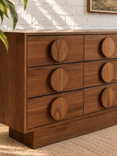 Load image into Gallery viewer, Nine-drawer Moonlight wood dresser with warm wood grain, low rectangular silhouette, and oversized round wooden drawer pulls
