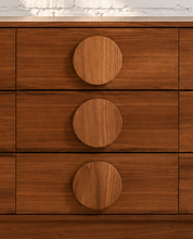 Load image into Gallery viewer, Nine-drawer Moonlight wood dresser with warm wood grain, low rectangular silhouette, and oversized round wooden drawer pulls
