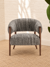 Load image into Gallery viewer, Abby charcoal grey textured bouclé accent chair with curved wraparound backrest, cushioned seat and exposed brown solid wood legs.
